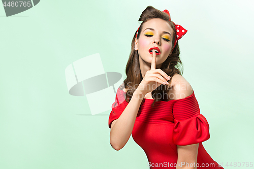 Image of Beautiful young woman with pinup make-up and hairstyle. Studio shot on white background