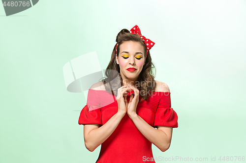 Image of Beautiful young woman with pinup make-up and hairstyle. Studio shot on white background