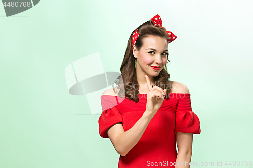 Image of Beautiful young woman with pinup make-up and hairstyle. Studio shot on white background