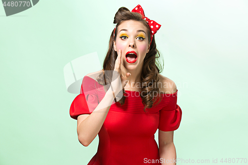 Image of Beautiful young woman with pinup make-up and hairstyle. Studio shot on white background