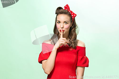 Image of Beautiful young woman with pinup make-up and hairstyle. Studio shot on white background