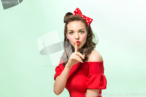 Image of Beautiful young woman with pinup make-up and hairstyle. Studio shot on white background