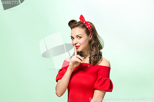 Image of Beautiful young woman with pinup make-up and hairstyle. Studio shot on white background