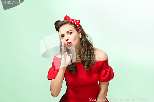 Image of Beautiful young woman with pinup make-up and hairstyle. Studio shot on white background