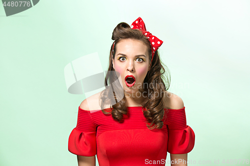 Image of Beautiful young woman with pinup make-up and hairstyle. Studio shot on white background