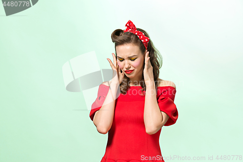 Image of Beautiful young woman with pinup make-up and hairstyle. Studio shot on white background