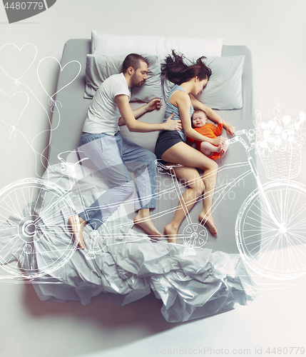 Image of Top view of happy family with one newborn child in bedroom and their dreams .