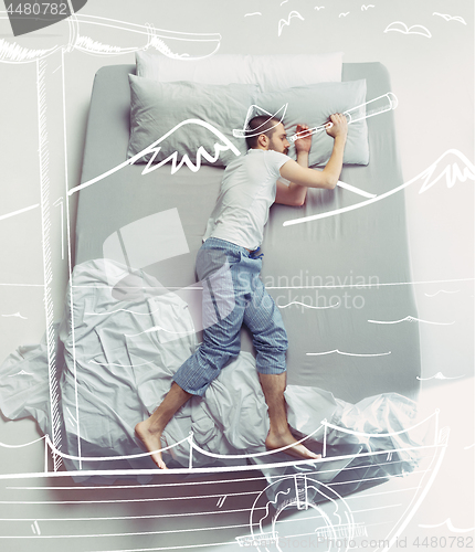 Image of Top view photo of young man sleeping in a big white bed and his dreams.