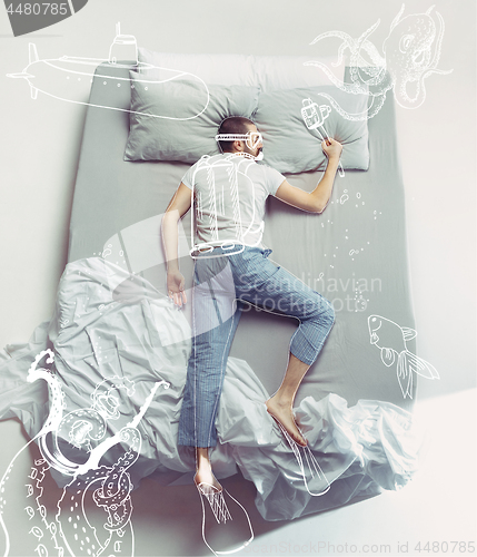 Image of Top view photo of young man sleeping in a big white bed and his dreams