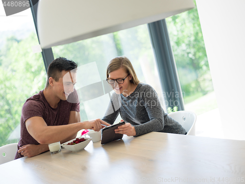 Image of couple enjoying morning coffee and strawberries