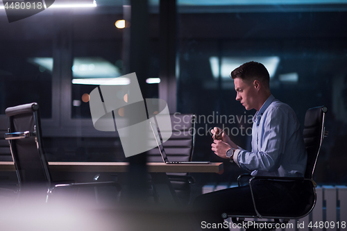 Image of man working on laptop in dark office