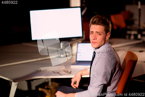 Image of man working on computer in dark office