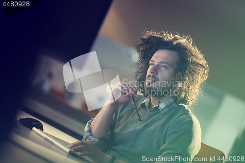 Image of man working on computer in dark office