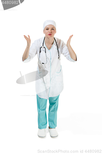 Image of Beautiful young woman is sending an air kiss in white coat posing at studio. Full length studio shot isolated on white.