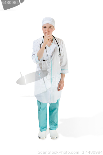 Image of Beautiful young woman is whispering a secret in white coat posing at studio. Full length studio shot isolated on white.