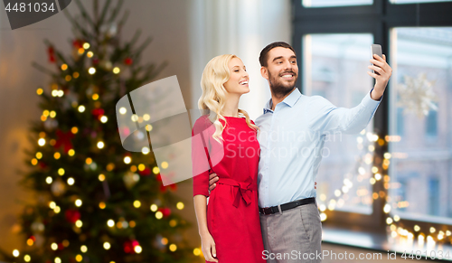Image of couple taking selfie by smartphone on christmas