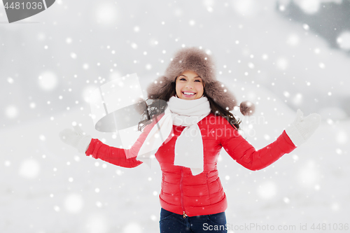 Image of happy smiling woman in winter fur hat outdoors