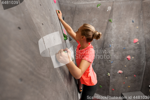 Image of young woman exercising at indoor climbing gym wall