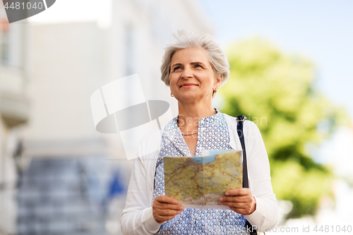 Image of senior woman or tourist with map on city street