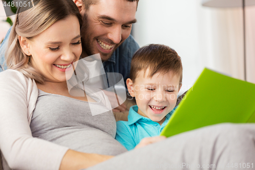 Image of happy family reading book at home