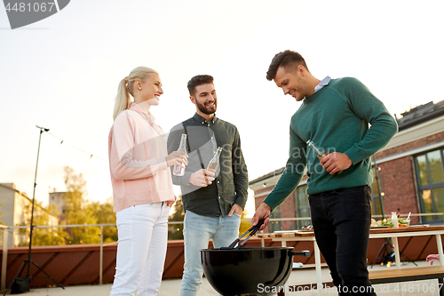 Image of happy friends having bbq party on rooftop