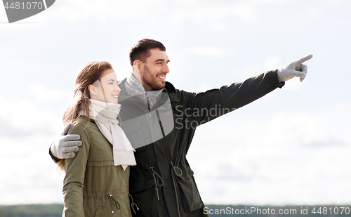 Image of smiling couple hugging on autumn beach