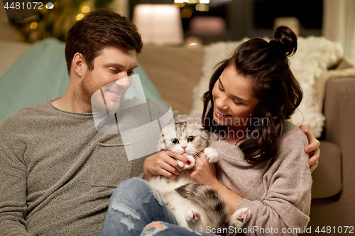 Image of happy couple with cat at home