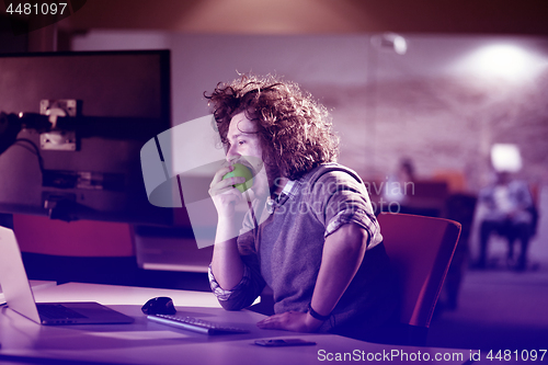 Image of man eating apple in his office