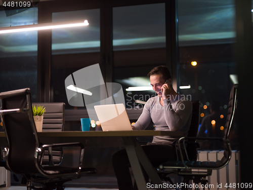 Image of man working on laptop in dark office