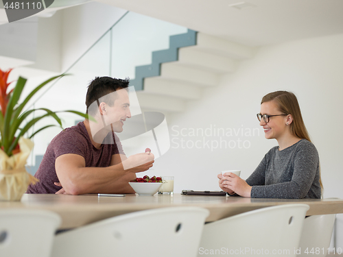 Image of couple enjoying morning coffee and strawberries