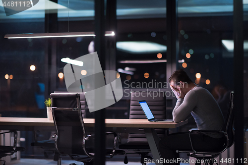 Image of man working on laptop in dark office