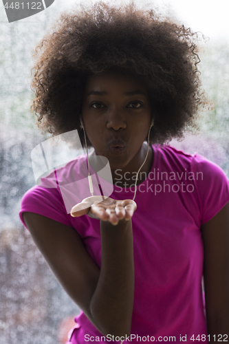 Image of portrait of young afro american woman in gym while listening mus