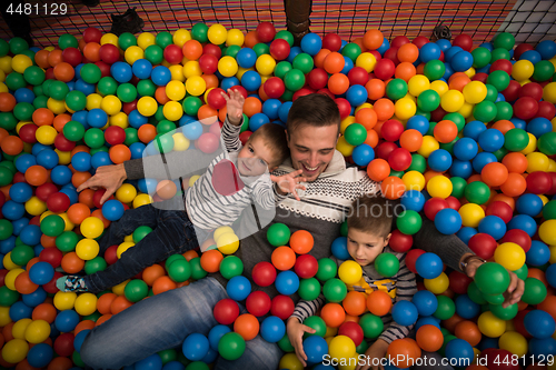 Image of Young dad with kids in a children\'s playroom