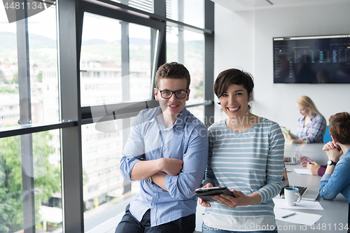 Image of Two Business People Working With Tablet in office