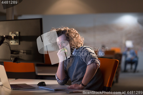 Image of man eating apple in his office