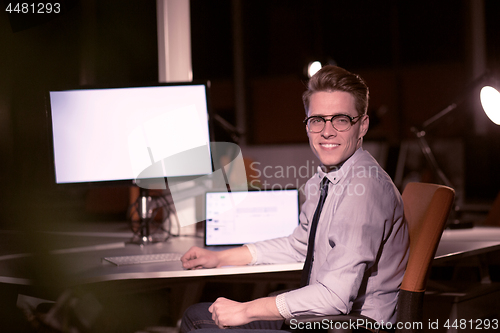 Image of man working on computer in dark office