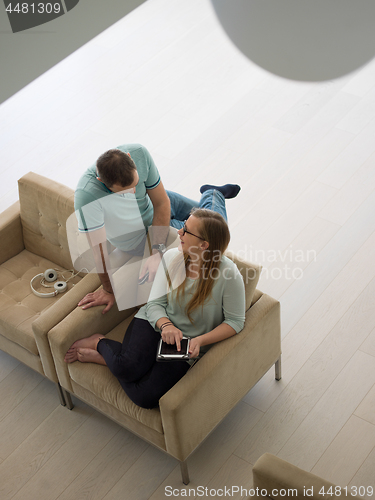 Image of couple relaxing at  home with tablet computers