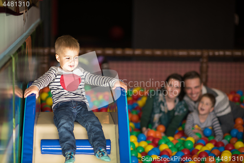 Image of young parents with kids in a children\'s playroom