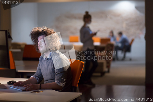 Image of man working on computer in dark office