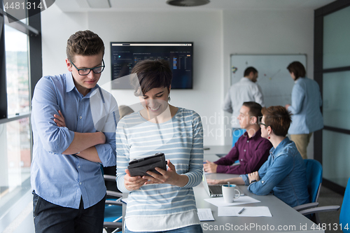 Image of Two Business People Working With Tablet in office