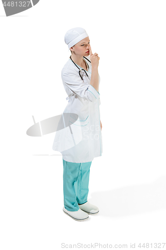 Image of Beautiful young woman is whispering a secret in white coat posing at studio. Full length studio shot isolated on white.