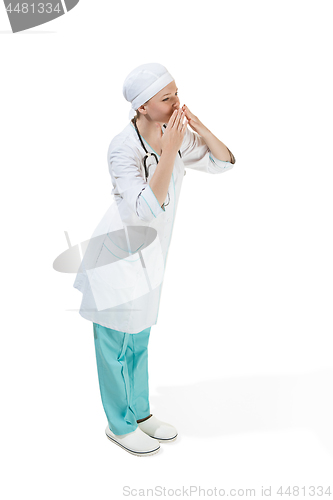 Image of Beautiful young woman is sending an air kiss in white coat posing at studio. Full length studio shot isolated on white.