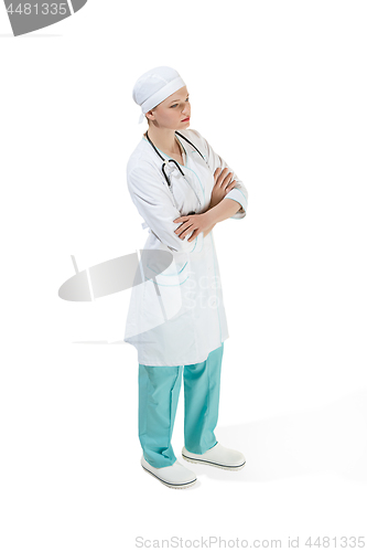 Image of Beautiful young woman is standing seriously in white coat posing at studio. Full length studio shot isolated on white.