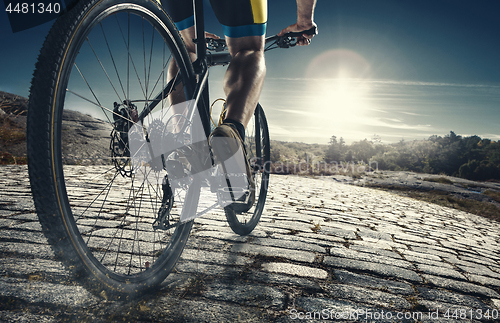 Image of Detail of cyclist man feet riding mountain bike on outdoor trail on country road