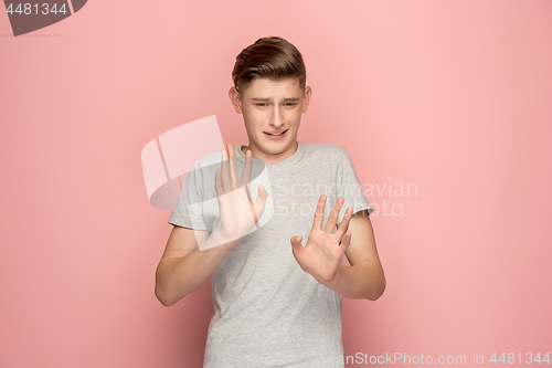 Image of Let me think. Doubtful pensive man with thoughtful expression making choice against pink background