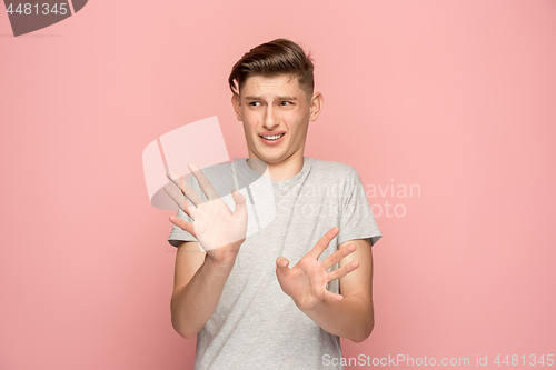 Image of Let me think. Doubtful pensive man with thoughtful expression making choice against pink background