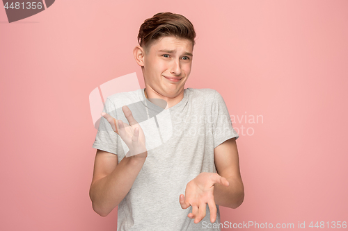 Image of Suspiciont. Doubtful pensive man with thoughtful expression making choice against pink background