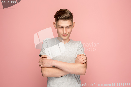 Image of The serious businessman standing and looking at camera against pink background.