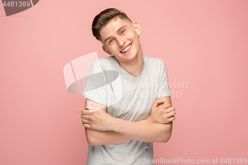 Image of The happy businessman standing and smiling against pink background.