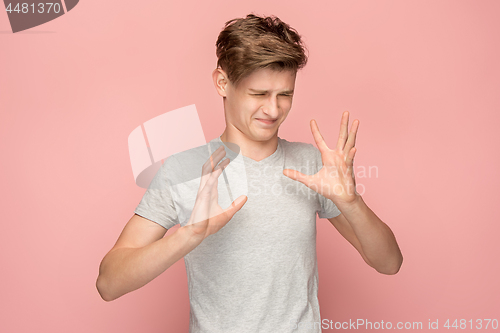 Image of Let me think. Doubtful pensive man with thoughtful expression making choice against pink background